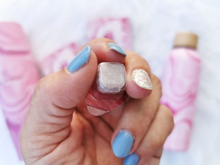 Nahaufnahme eines abgepackten Waterdrop-Würfels, gehalten zwischen den Fingern