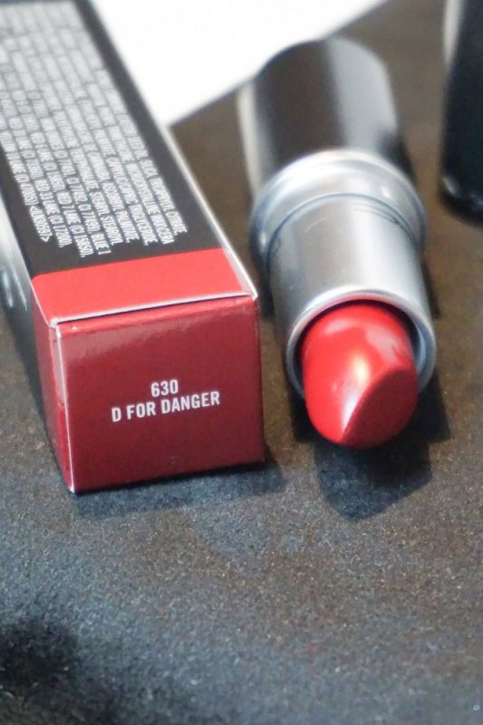 Nahaufnahme des MAC Lippenstifts „D for Danger“ – sattes Rot mit Beerenton, in eleganter schwarzer Hülse präsentiert.
