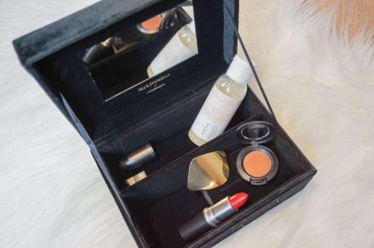 Dunkelblaue Samtschatulle der My Little Box mit MAC-Produkten auf weißem Fell – Lidschatten, Lippenstift und Pflegeartikel dekorativ arrangiert.