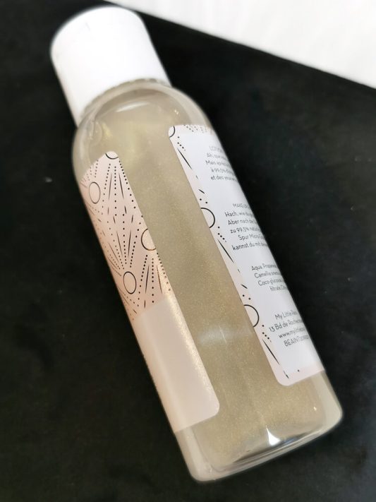 Make-up-Entferner-Lotion der My Little Box im Detail – champagnerfarbener Perlmutt-Schimmer sichtbar, elegante Flasche dekorativ präsentiert.