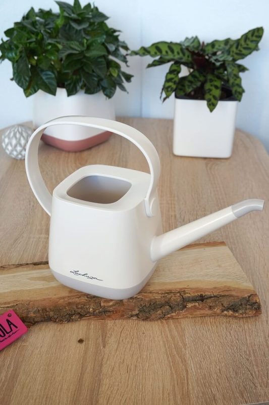 Weiße Lechuza #myYula Gießkanne auf Holzbrett, hochkant, mit grünen Pflanzen im passenden Lechuza-Pflanztopf – stilvolles Gießzubehör für Zuhause