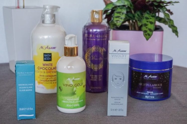 Asam Beauty Produkte aus einer Geschenktüte ausgepackt – Pflegeprodukte aufgereiht für den Produkttest.