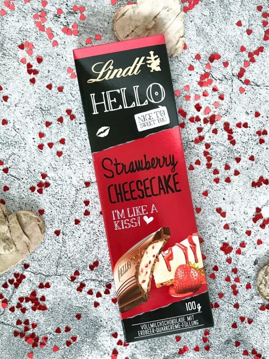 Lindt HELLO Tafel „Strawberry Cheesecake“ – weiße Schokolade mit Erdbeer- und Cheesecake-Akzenten.