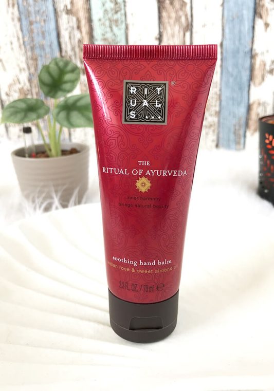 Rituals Handcreme The Ritual of Ayurveda in Muschelschale, umgeben von Babypflanze und Kerze – entspannendes Pflege-Setting.