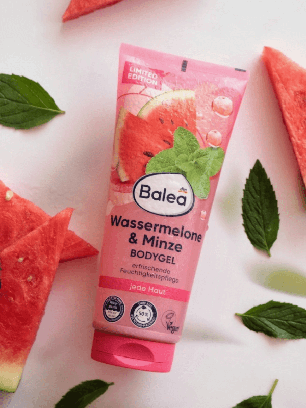 Balea Bodygel Wassermelone-Minze hochkant fotografiert, mit Wassertropfen besprenkelt, dekoriert mit Wassermelonenstücken und frischer Minze auf weißem Untergrund