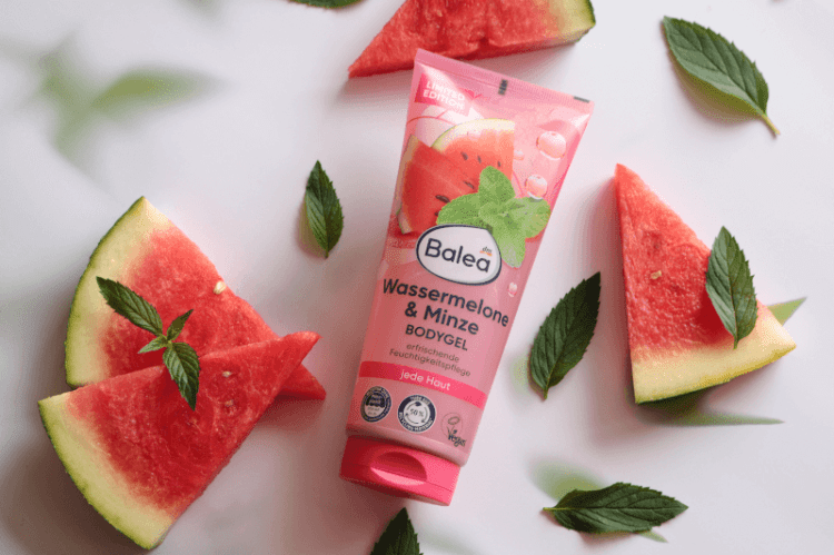 Balea Bodygel Wassermelone-Minze auf weißem Untergrund, dekoriert mit frischen Wassermelonenstücken und Minzblättern